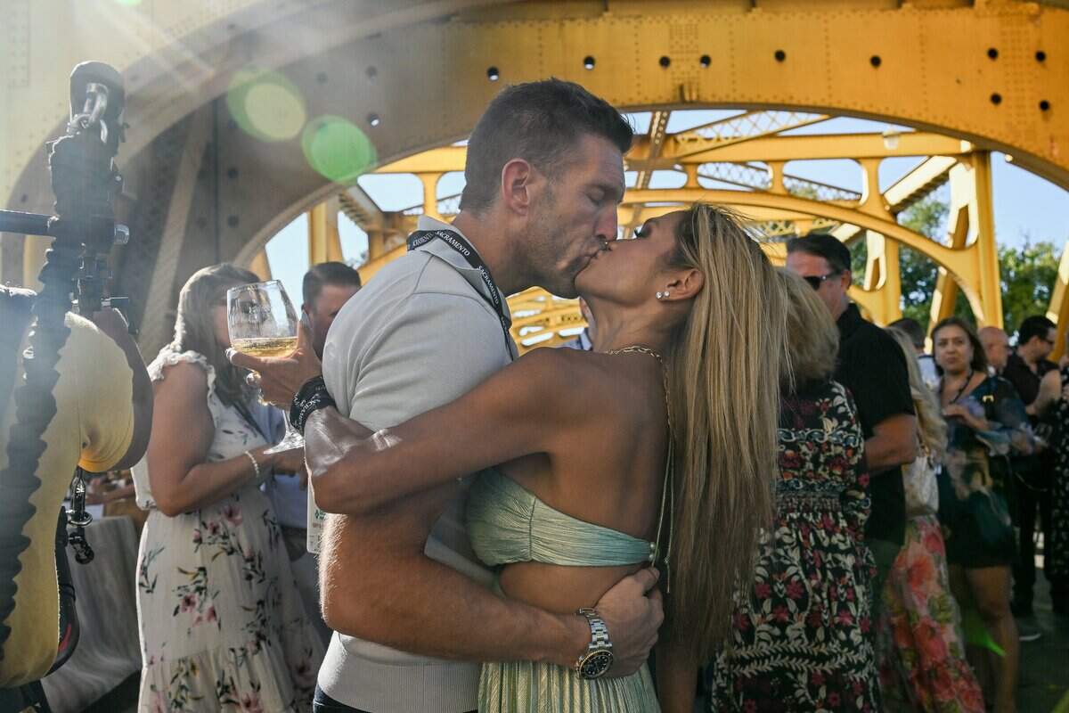 Guest Brandon Haefele, left, kisses his wife Mae Fesai-Haefele during the Tower Bridge dinner in Sacramento on Sunday.