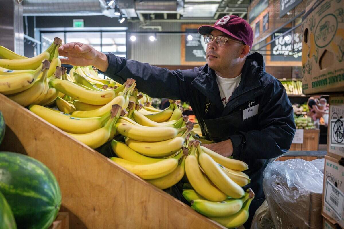 Produce clerk Paul Supat restocks bananas at Sacramento Natural Foods Co-op on Tuesday, Sept. 1, 2026.