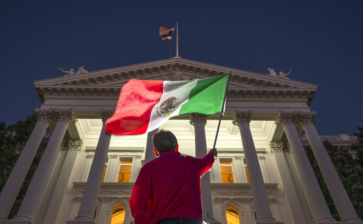 A participant waves the Mexican flag during a celebration of the 216th anniversary of Mexican independence at the state Capitol on Tuesday.