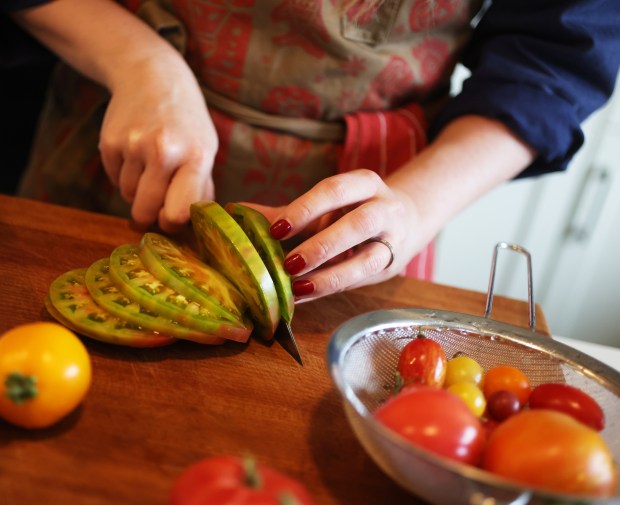 Ukrainian-born chef Anna Voloshyna, author of "Ukraïne: Recipes and Stories From Kyiv to the Black Sea," slices summer tomatoes in her Oakland kitchen on Sunday, Aug. 30, 2026. (Aric Crabb/Bay Area News Group)