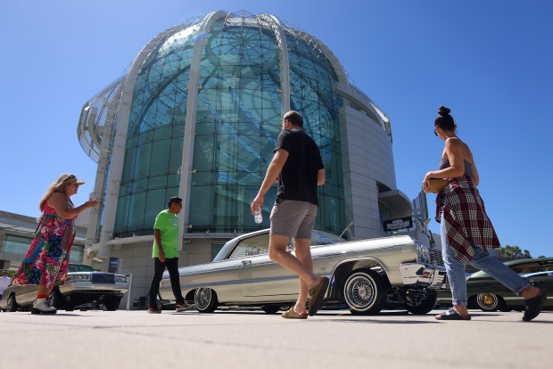 Visitors look over cars on display during the annual San Jose Lowrider Day at City Hall on Sunday, Sept. 1, 2024, in San Jose, Calif. The event commemorates San Jose's repeal of the decades-long ban on cruising in 2022. (Aric Crabb/Bay Area News Group)