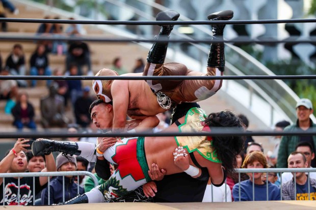 Luchadores Genesis, left, Gallero, top, Cruz Negra and Azteca perform during Lucha Libre Wrestling Night at Thrive City Plaza in San Francisco, Calif., Thursday, Sept. 24, 2026. Twenty-two wrestlers performed in six matches during the free event hosted by West Coast Pro Wrestling and Pro Wrestling Revolution. (Ray Chavez/Bay Area News Group)