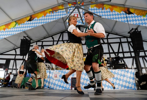 Diane Battilana, center, from Oakland, and Don Pape, from Alameda, both with Nature Friends Schuhplattler perform at the Redwood City Oktoberfest in downtown Redwood City, Calif., on Wednesday, Sept. 20, 2023. (Nhat V. Meyer/Bay Area News Group)