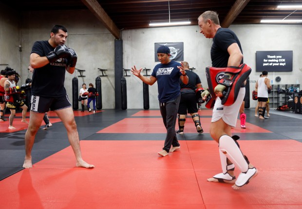 Head Coach Ed Carpio, center, observes Alex "AP" Pasos, left, and Reid Rokitta, both from San Jose, during the Muay Thai Pad Work class at Condition and Competition Kickboxing, also known as Team CCK, in San Jose, Calif., on Tuesday, Sept. 1, 2026. (Nhat V. Meyer/Bay Area News Group)