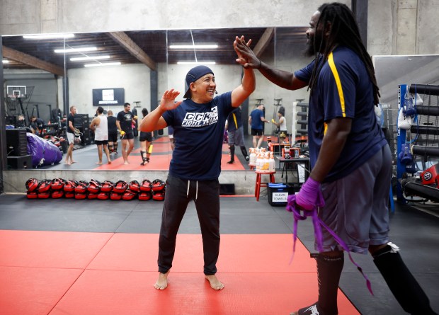 Head Coach Ed Carpio, left, high-fives Emil Stephens, from San Jose, at the end of the Muay Thai Pad Work class at Condition and Competition Kickboxing, also known as Team CCK, in San Jose, Calif., on Tuesday, Sept. 1, 2026. (Nhat V. Meyer/Bay Area News Group)