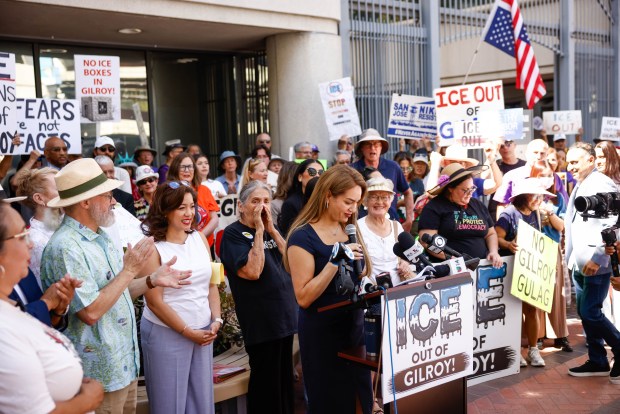 People hold up signs as Santa Clara County Supervisor Sylvia Arenas speaks during a press conference before a case hearing between Santa Clara County and ICE at the Federal Courthouse in San Jose, Calif., on Tuesday, Sept. 8, 2026. (Shae Hammond/Bay Area News Group)