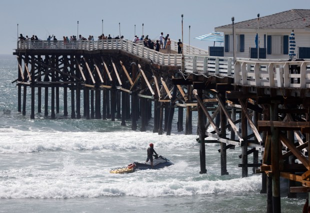 San Diego, CA - September 7: A San Diego lifeguard patrols the water as people gather on the Crystal Pier in Pacific Beach for Labor Day as large surf generated by Hurricane Marie slams the Southern California coast on September 7, 2026 in San Diego, CA. (K.C. Alfred / The San Diego Union-Tribune)