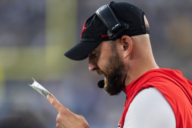 SDSU coach Sean Lewis looks at his play sheet during a game against UCLA on Saturday.(Luke Johnson / The San Diego Union-Tribune)