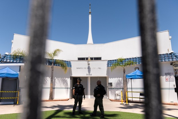 Security guards stand in the front of the Islamic Center of San Diego on Monday. (Luke Johnson / The San Diego Union-Tribune)