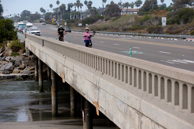 Encinitas, CA - September 10: Cyclists ride on a bridge on Coast Highway 101 that crosses the inlet to San Elijo Lagoon on September 10, 2026 in Encinitas, CA. (K.C. Alfred / The San Diego Union-Tribune)