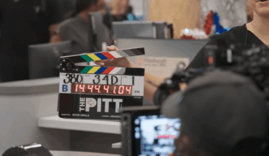 A woman holds a clapperboard in front of a camera on the set of The Pitt.