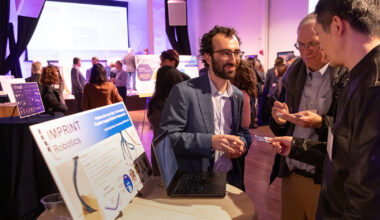 A group of people gather at a mixer event to discuss new business ventures. They