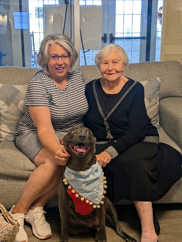 Katie Tolly, left, and her mother, Carol Tolly, share a moment with Beulah, Katie's rescue dog and a participant in the St. Anne's Mead Pet Parade & Blessing. Katie now regularly brings Beulah and her cat to visit Carol and other residents at St. Anne's Mead Assisted Living. (Photo courtesy of St. Anne's Mead Assisted Living)
