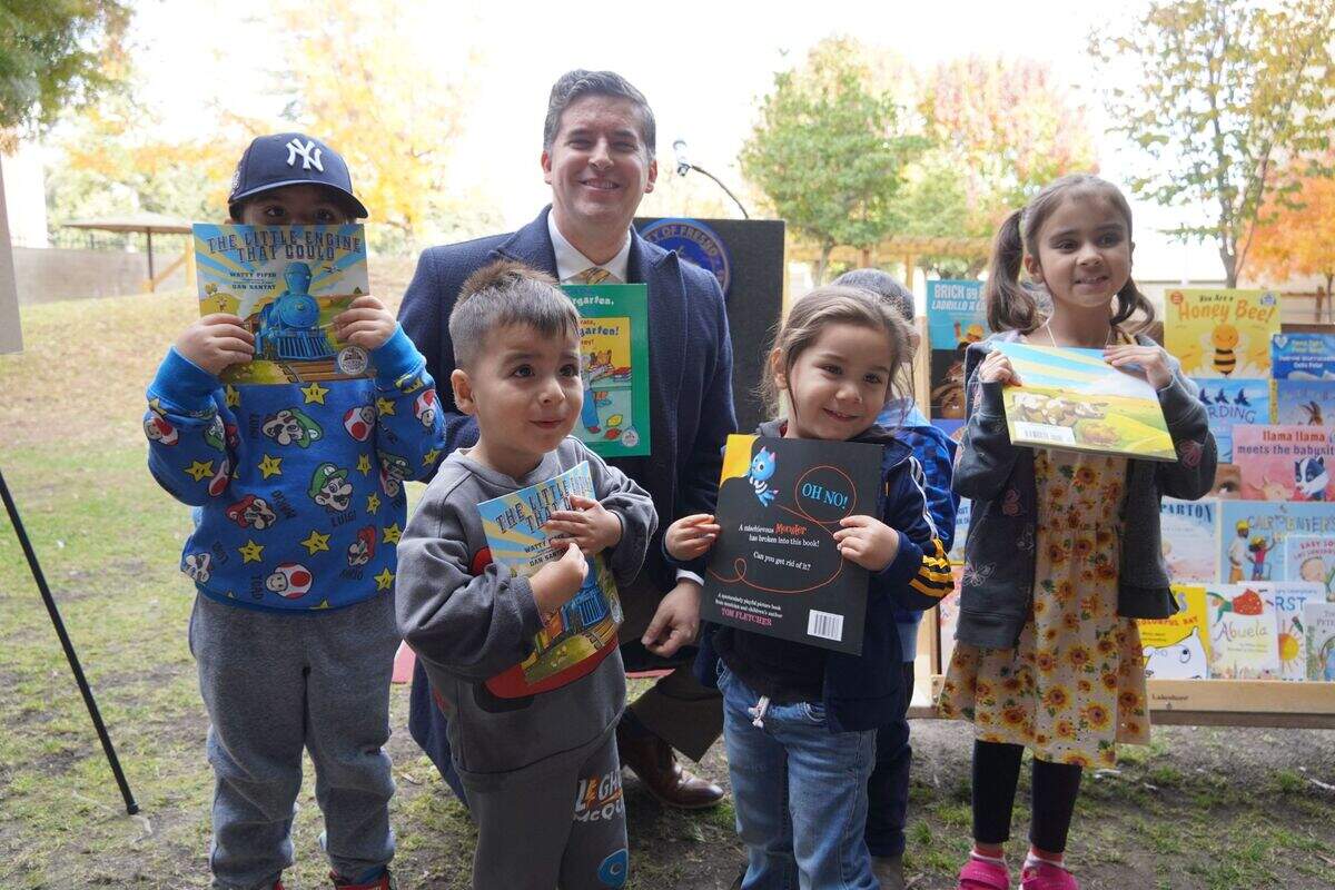 Fresno City Councilmember Tyler Maxwell poses with strikes a pose with four kids in support of children’s literacy. Maxwell set aside $150,000 in federal stimulus funding that will help launch Dolly Parton’s Imagination Library in Fresno County.