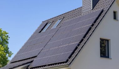 Solar panels installed on the roof of a house under a clear blue sky.
