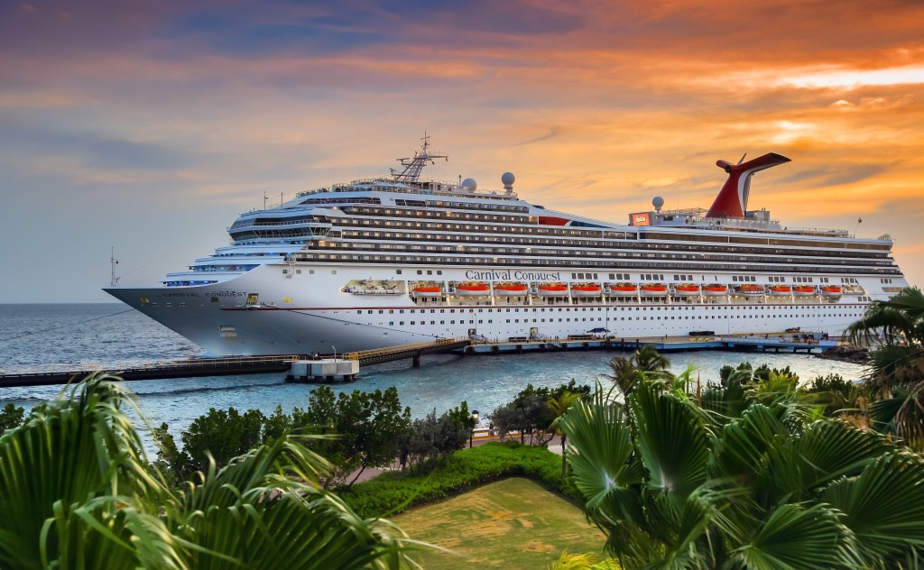Cruise ship Carnival Conquest docked at port Willemstad at sunset.