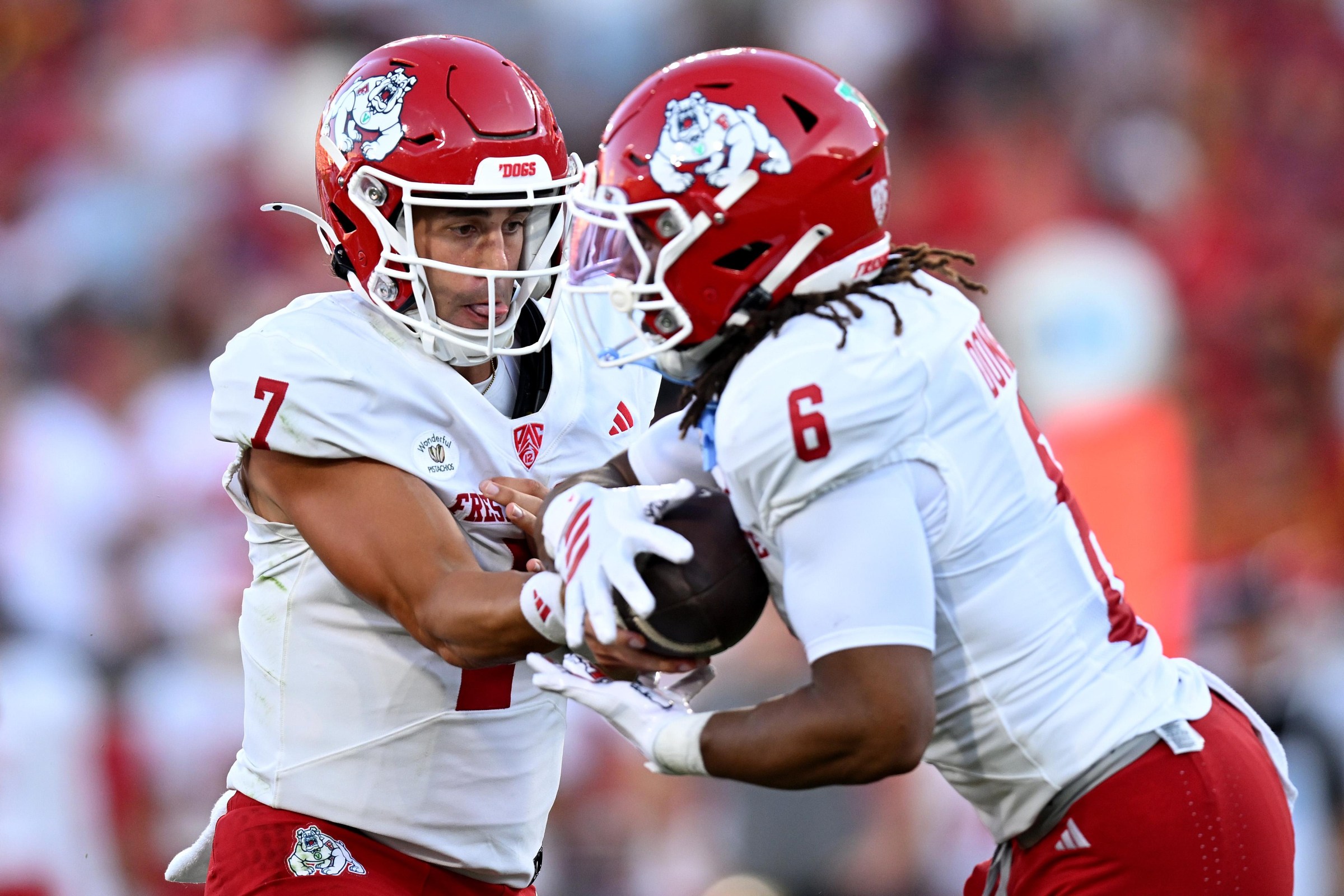 LOS ANGELES, CALIFORNIA - SEPTEMBER 04: Jayden Mandal #7 of the Fresno State Bulldogs hands the ball off to Bryson Donelson #6 against the USC Trojans during the first quarter at Los Angeles Memorial Coliseum on September 04, 2026 in Los Angeles, California. (Photo by Griffin C. Hooper/Getty Images)