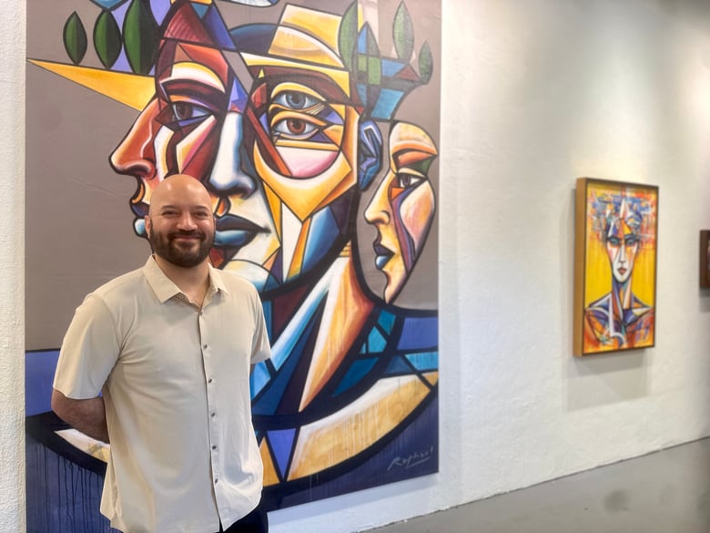 Raphael Delgado is seen in front of his art work at Twisted Track Gallery in Sacramento. The arists has a solo exhibition, "Raphael," which runs through Sept. 27. Vicki Gonzalez/CapRadio