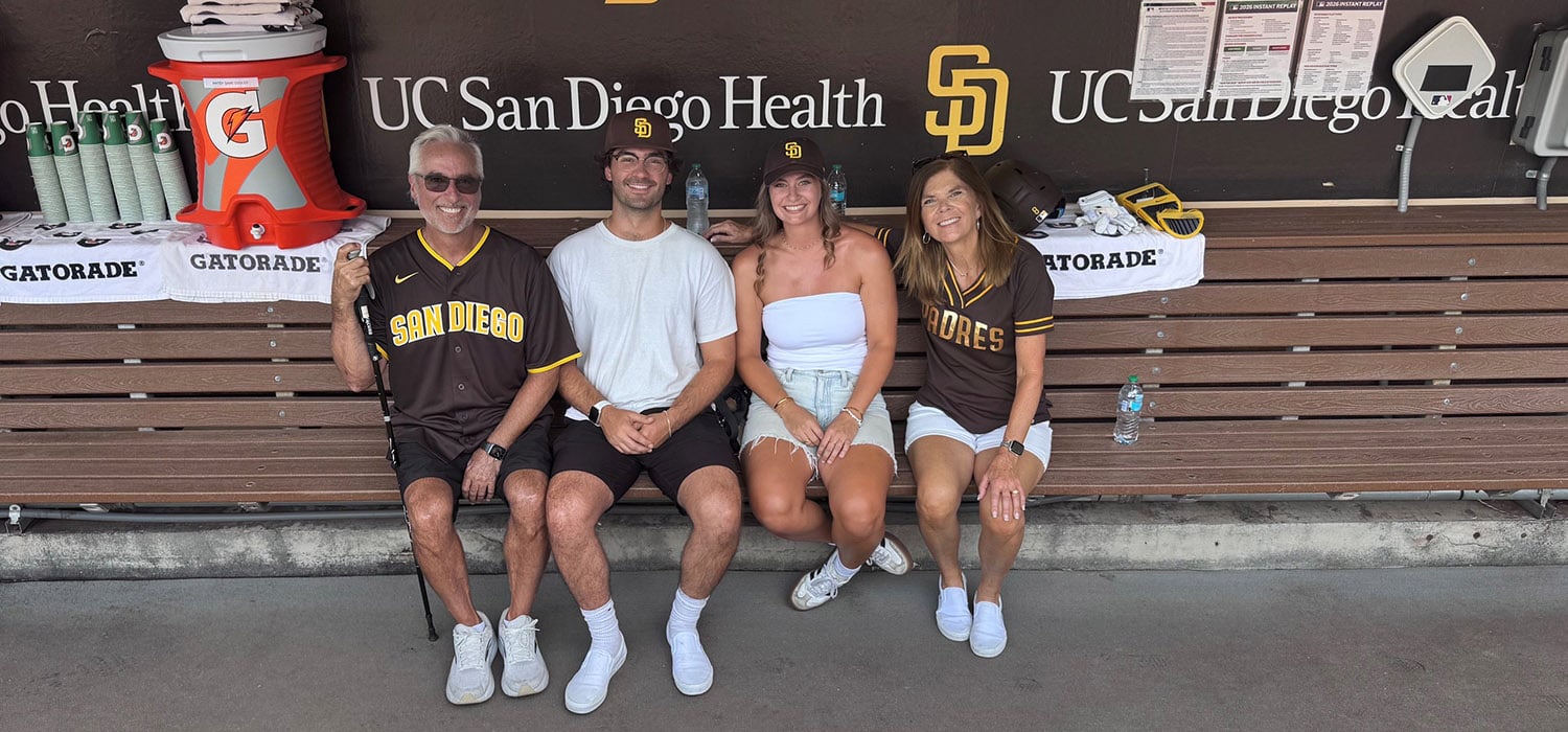Family of four sitting in dugout at San Diego Padres game
