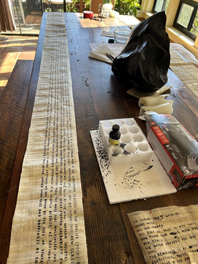 A cream-colored scroll unrolled along a table, with English words written in black ink.