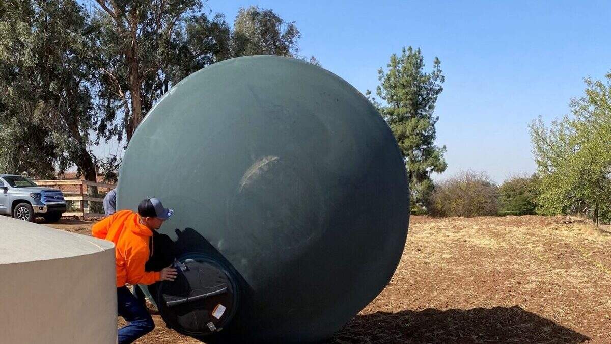 Workers roll a 2,500-gallon water storage tank from Self-Help Enterprises onto a property where a well had gone dry in 2021. COURTESY: Linda Reese Workers roll a 2,500-gallon water storage tank from Self-Help Enterprises onto a property where a well had gone dry in 2021. COURTESY: Linda Reese