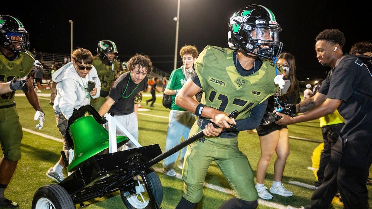 Ryan Guzman carries the Bell across the field after Victor Valley beats Apple Valley.