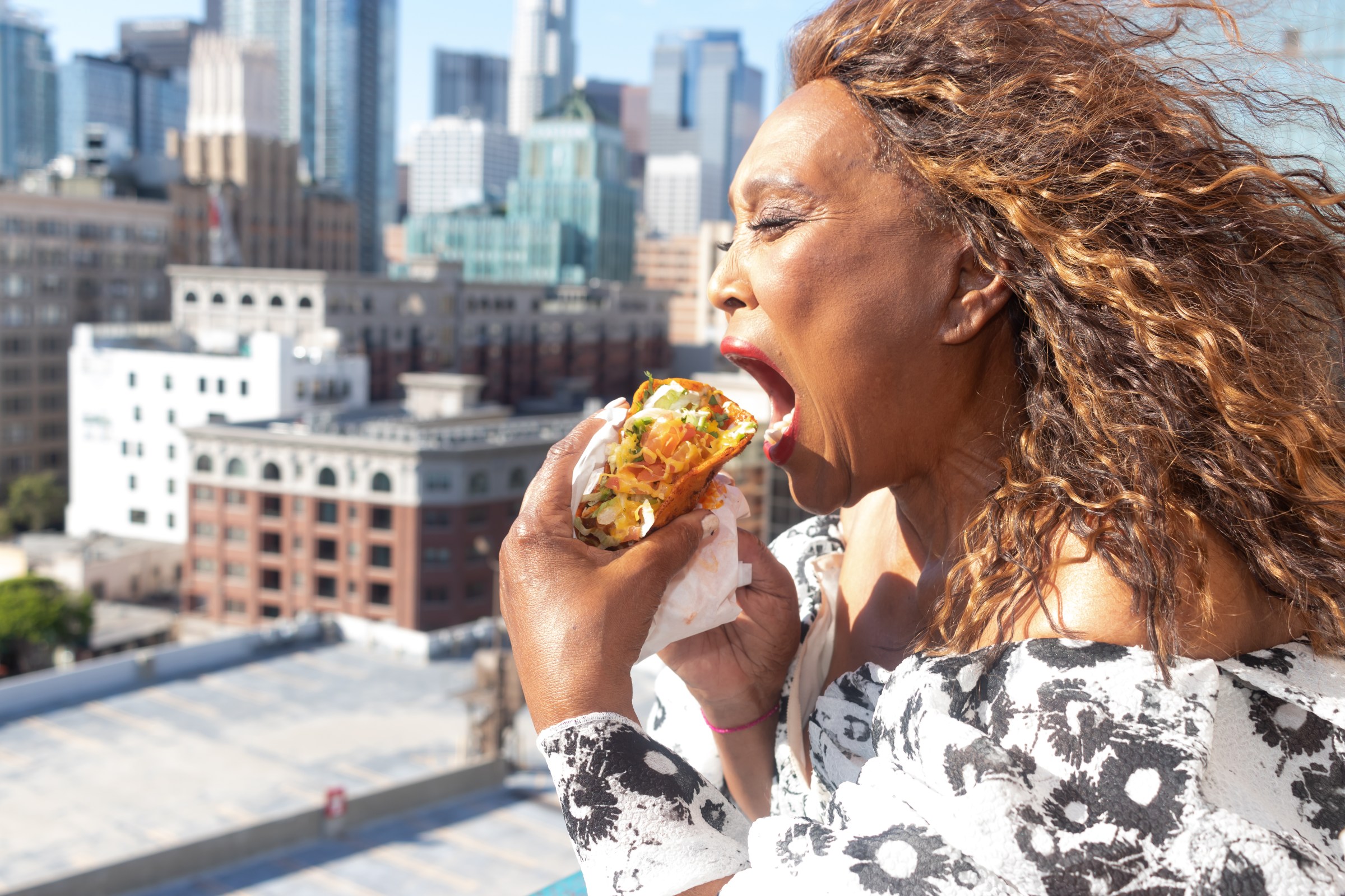Barbara “Sky” Burrell of Sky’s Gourmet Tacos biting into a taco in Los Angeles, California
