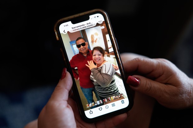 On Aug. 11, 2026, Carmen Zavala shows an old photograph of her with her then-husband Jeff Belle, now a Republican candidate for Congress in South County. "I went through hell," she said of the marriage. (Nelvin C. Cepeda / The San Diego Union-Tribune)