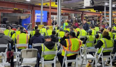 warehouse floor with workers in high visibility gear gathered