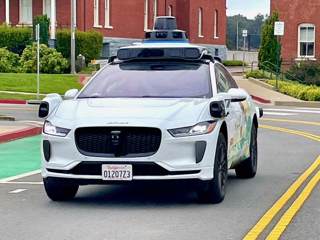 A Waymo self-driving taxi traveling through The Presidio's Parade Ground in San Francisco.
