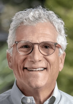 man with white hair wearing glasses