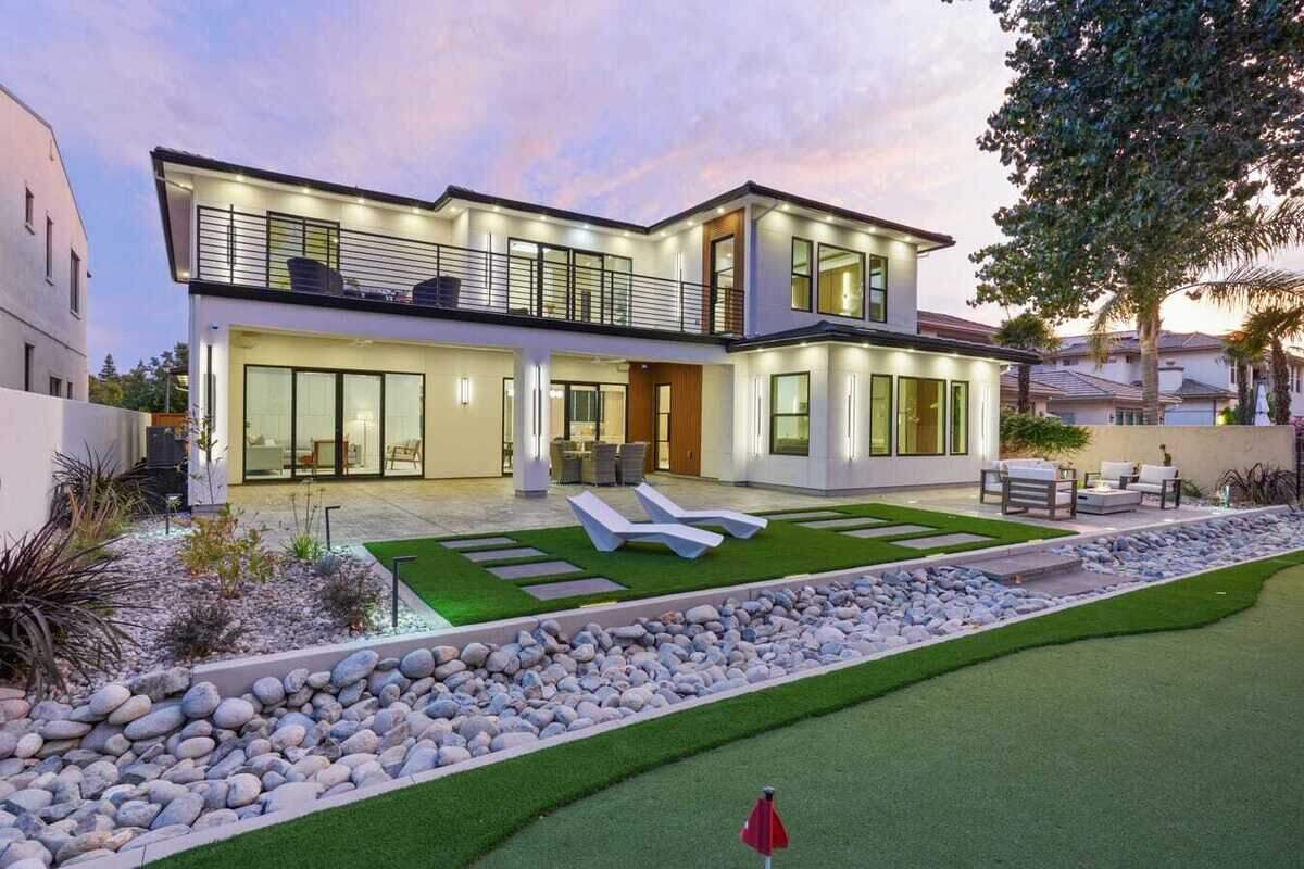 The riverside backyard is designed for evening entertaining, with LED lighting integrated into the steps and pavers, a gas fire pit and wall sconces. A private putting green is in place, too.