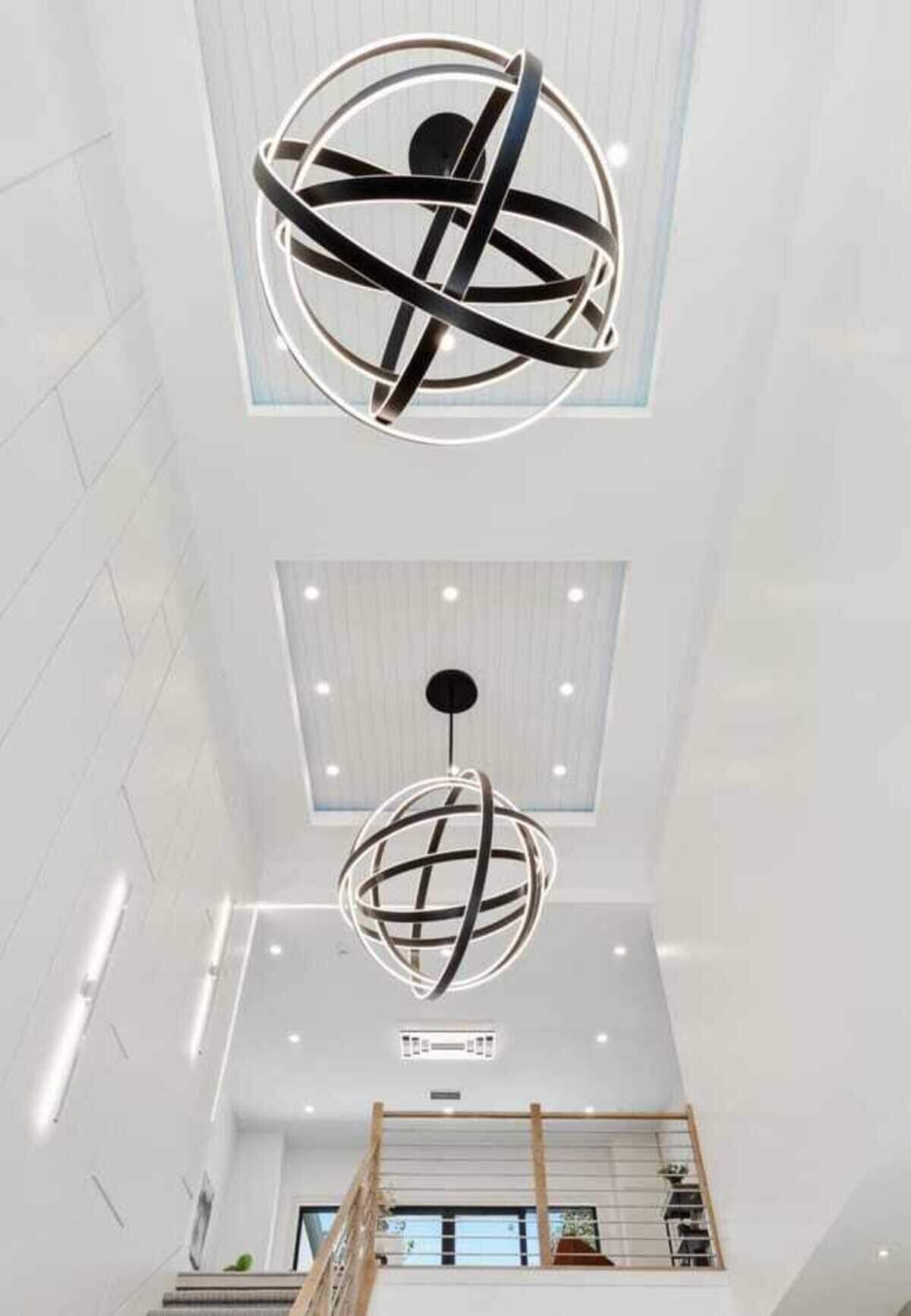 Two large statement fixtures, each measuring roughly 5 to 6 feet across and weighing about 100 pounds, hang above the entry foyer.