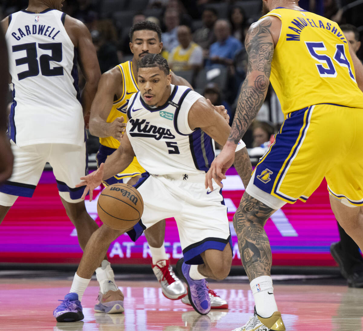 Sacramento Kings guard Darius Acuff Jr. maneuvers between Los Angeles Lakers guard Quentin Grimes (5) and forward Sandro Mamukelashvili (54) during the NBA preseason game Monday, Oct. 5, 2026, at Golden 1 Center.