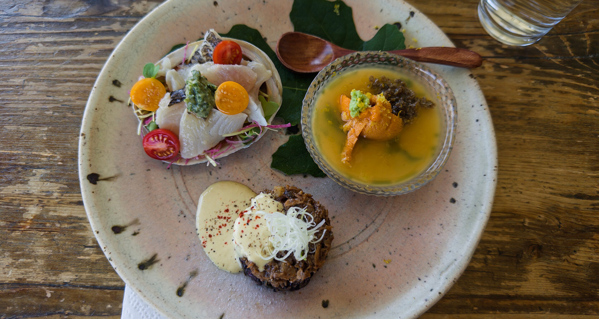 A trio of Japanese appetizers on a plate: sashimi, egg custard and a pate-like head cheese.