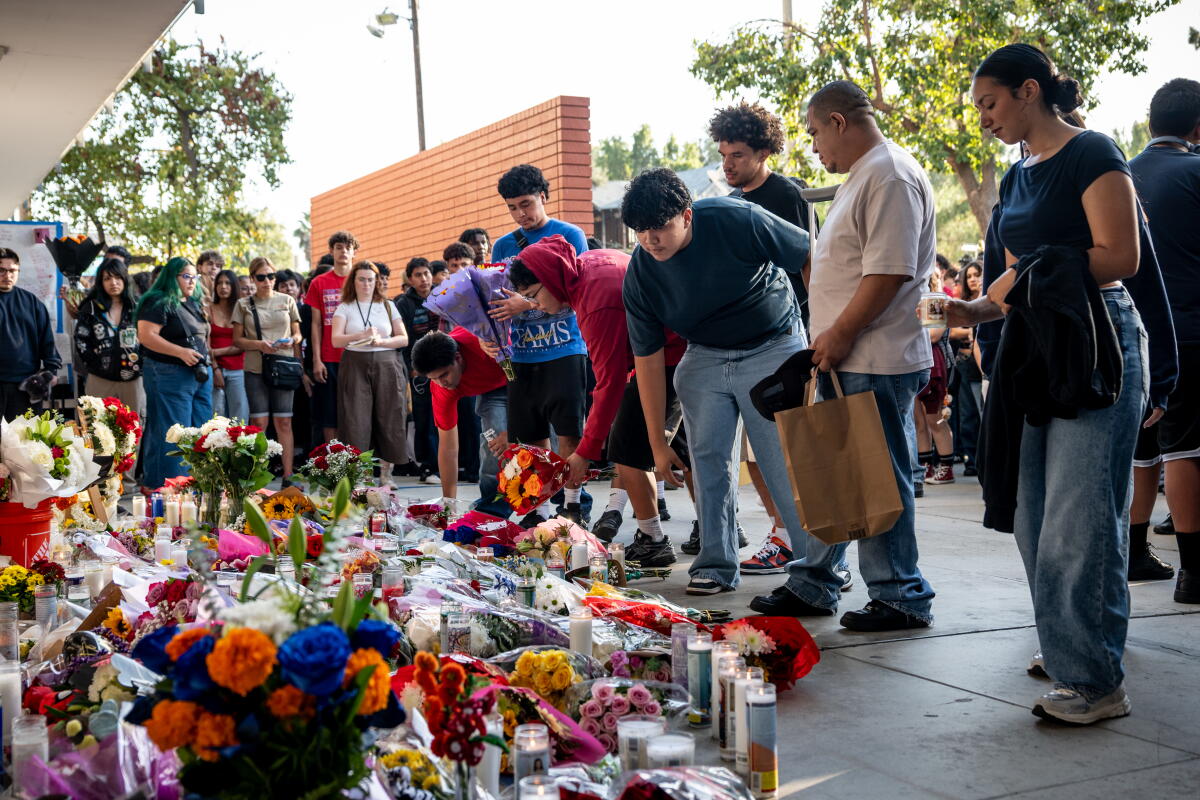Students lay flowers at a vigil