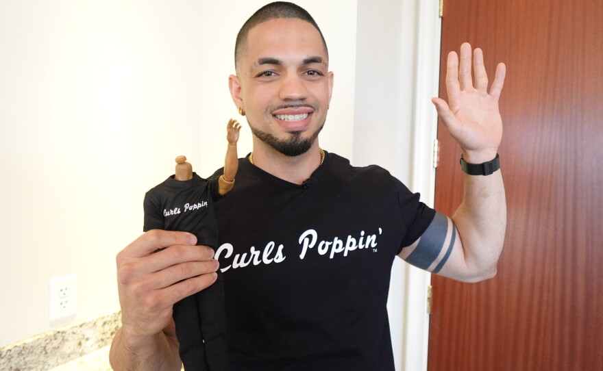 Emmanuel Rodriguez holds a prototype doll made in his likeness on Sept. 22, 2026, at the University Club of San Diego.