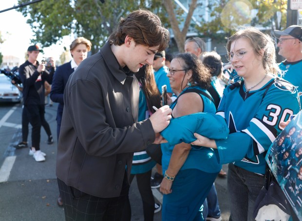 San Jose Sharks' Luca Cagnoni (42) signs autographs during the Teal Carpet arrivals before their first home game against the Florida Panthers at the SAP Center in San Jose, Calif., on Thursday, Oct. 1, 2026. (Nhat V. Meyer/Bay Area News Group)