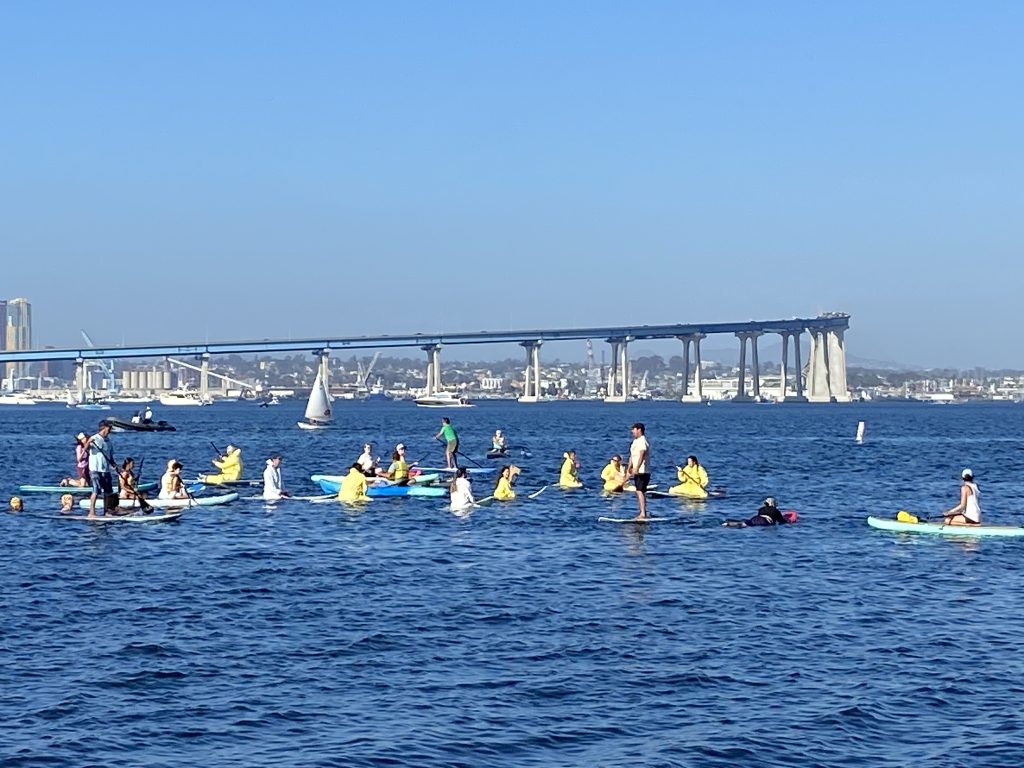 SD Climate week paddle out in Glorietta Bay with bridge in background.