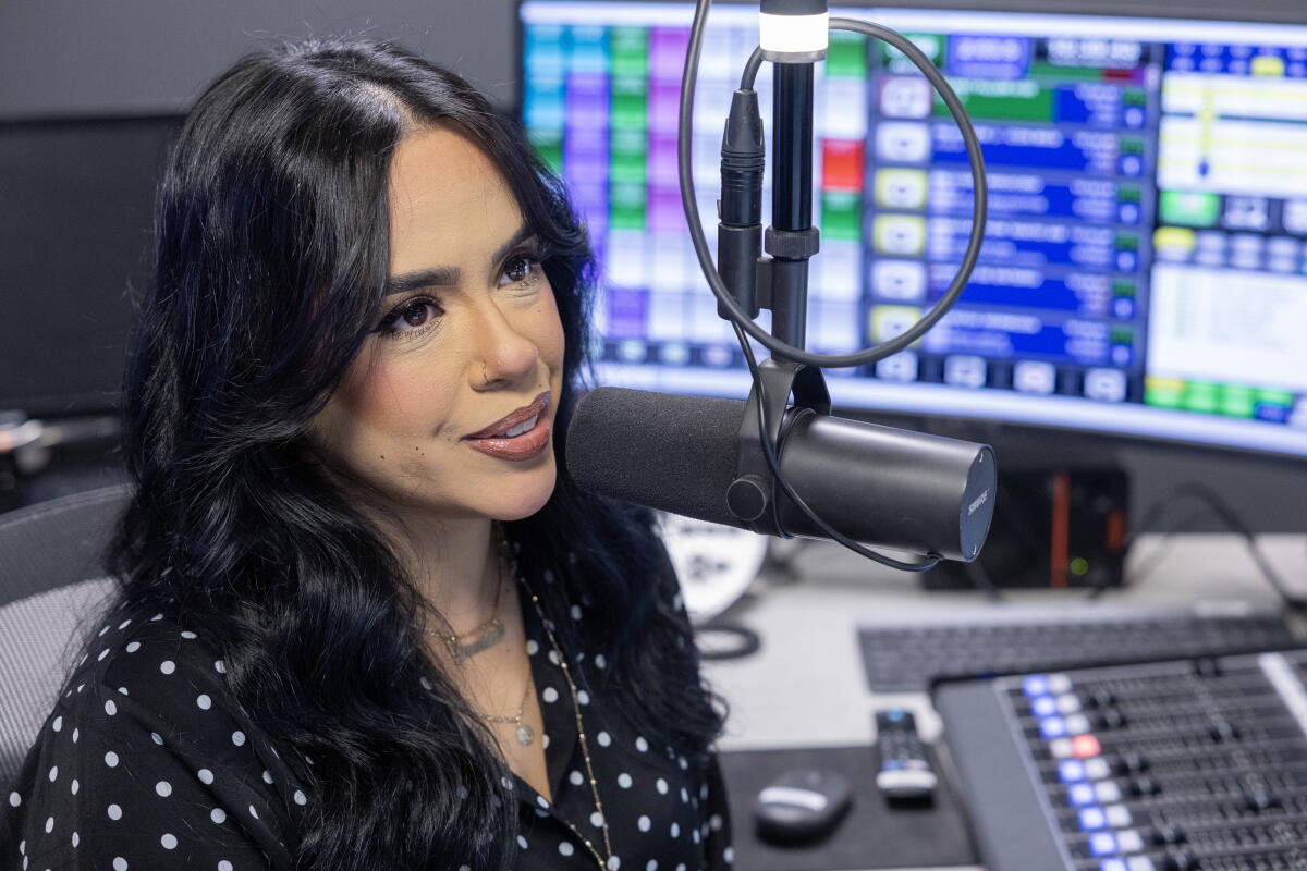 Geraldine "GeeGee" Guzman hosts a radio show on José 97.5 FM  while looking at a computer  screen