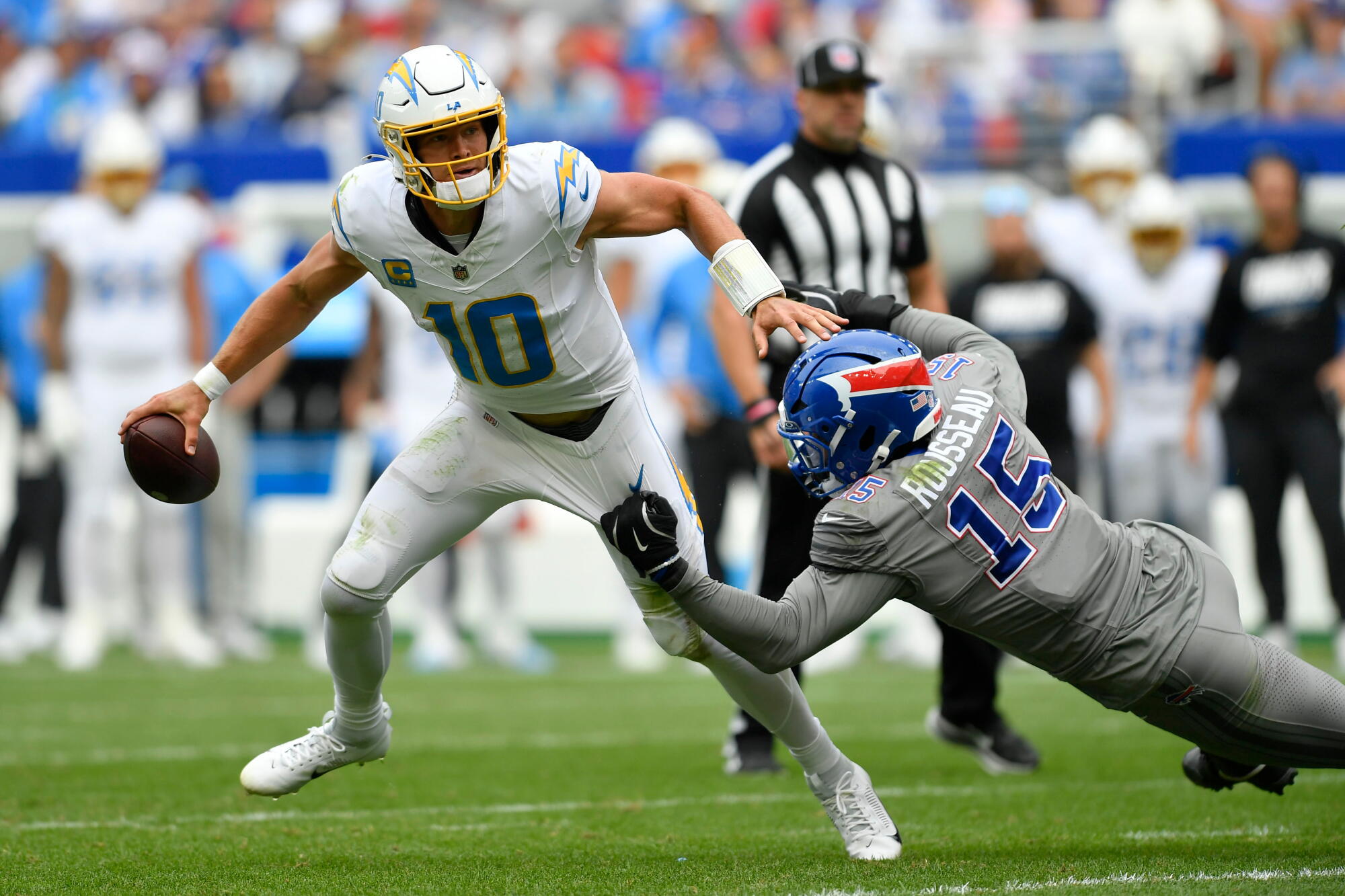 Chargers quarterback Justin Herbert tries to avoid being sacked by Buffalo Bills linebacker Greg Rousseau.