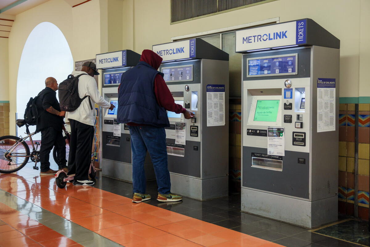 Patrons buy tickets at a Metrolink ticket booth in Los Angeles' Union Station on Sunday.