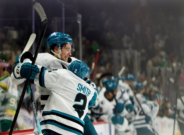 San Jose Sharks center Macklin Celebrini, top left, celebrates with center Will Smith (2) after scoring the winning goal during overtime of an NHL hockey game against the Minnesota Wild, Sunday, Oct. 26, 2025, in St. Paul, Minn. (AP Photo/Ellen Schmidt)
