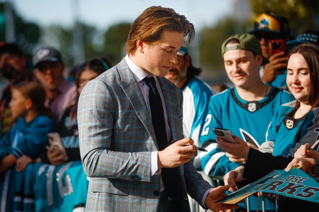 San Jose Sharks' Macklin Celebrini (71) signs autographs for fans during a pregame ceremony before the San Jose Sharks' home opener against the Vegas Golden Knights at the SAP Center in San Jose, Calif., on Thursday, Oct. 9, 2025. (Shae Hammond/Bay Area News Group)