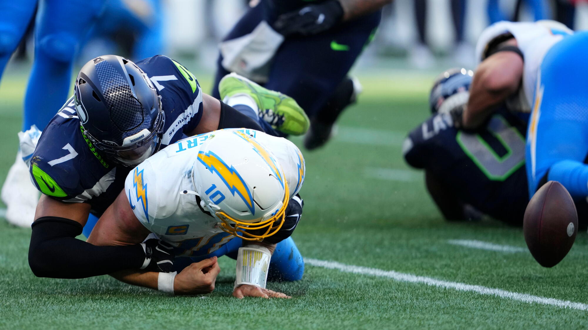 Chargers quarterback Justin Herbert fumbles as he is tackled by Seattle Seahawks linebacker Uchenna Nwosu.