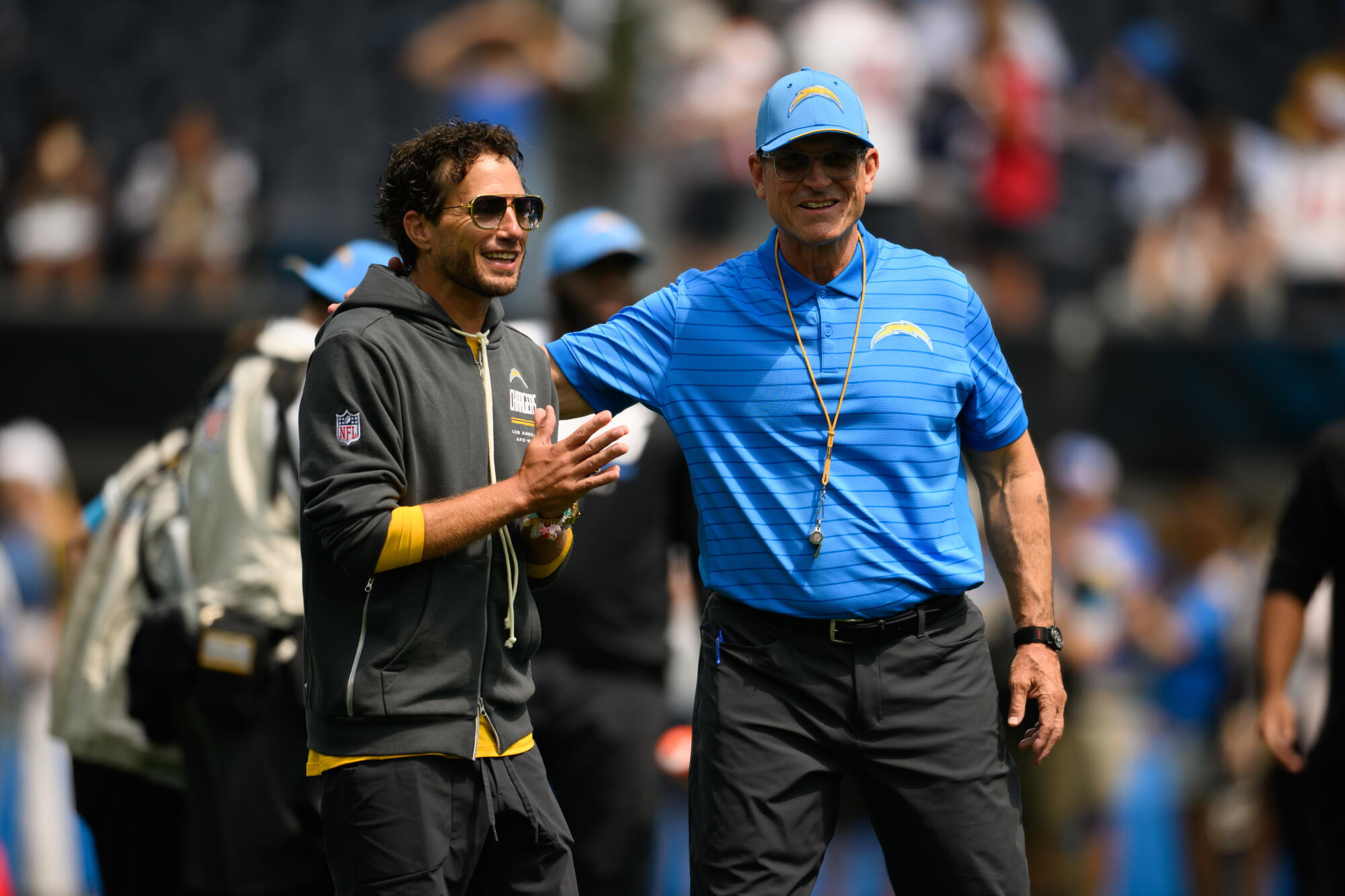 Chargers offensive coordinator Mike McDaniel, left, stands next to head coach Jim Harbaugh.