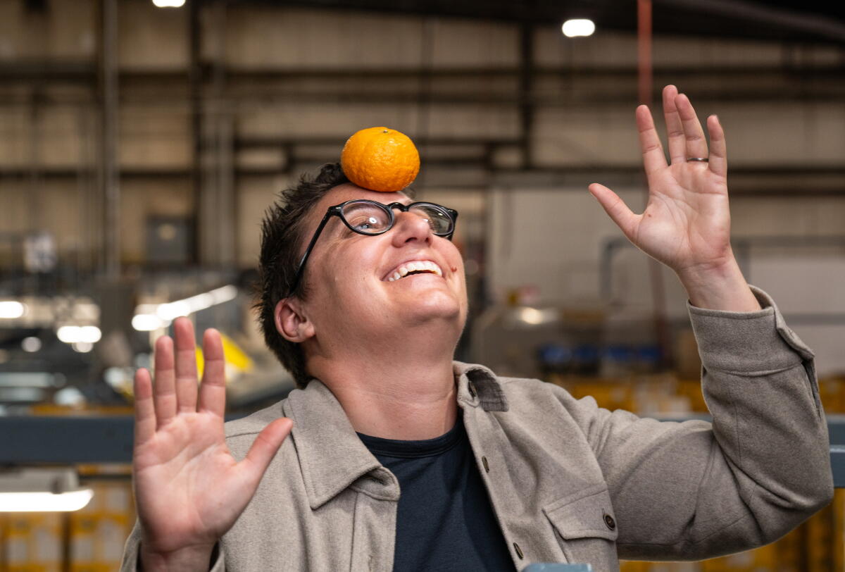 Farm owner Bianca Kaprielian balancing an orange on their forehead