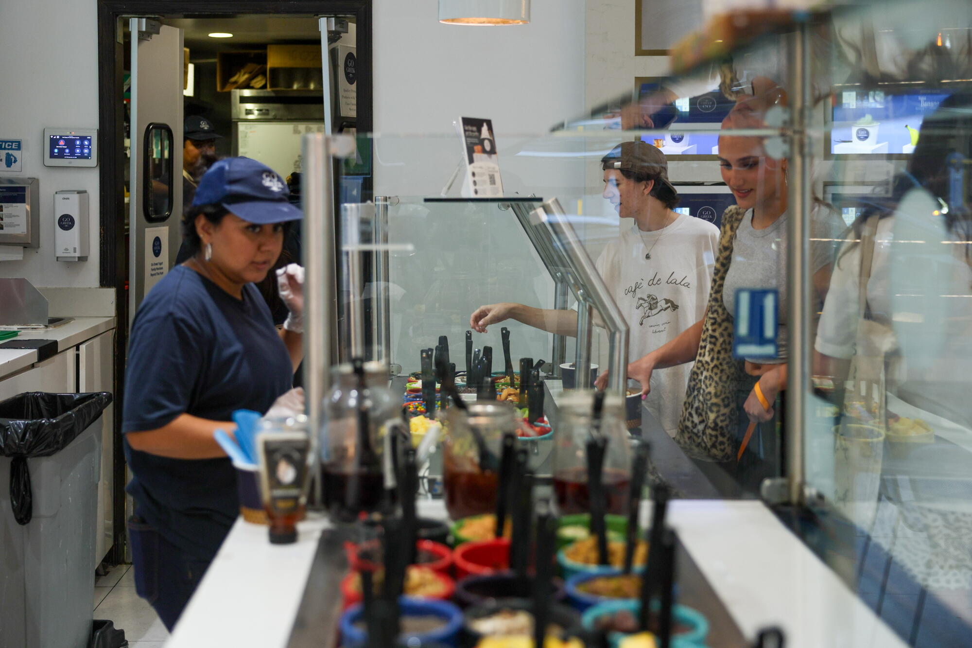 People wait in line to order custom yogurt bowls at Go Greek in Beverly Hills