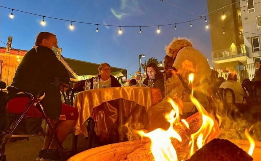 Patron sit near a a fire during a past Ghost Stories event at Pop-Up Winona in this undated photo.
