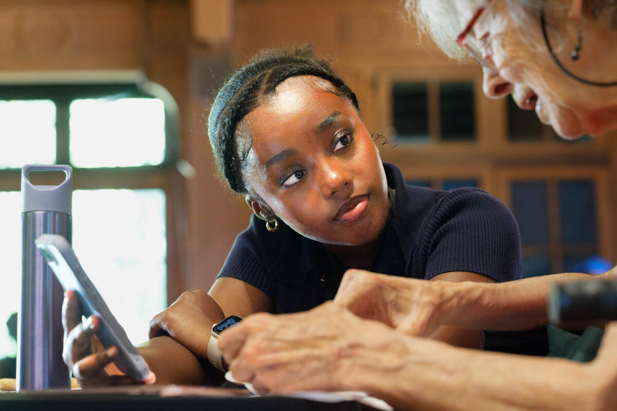 Heven Adugna, 17, teaches Diana Young, 82, with her iPhone at Mills College at Northeastern University in Oakland.
